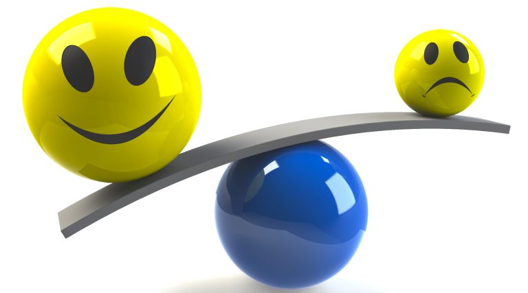 Lachender Smiley und trauriger Smiley auf einer Wippe