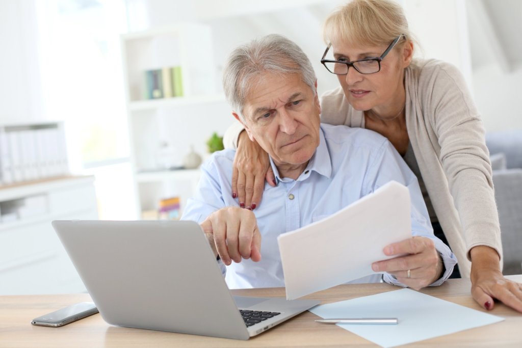 Ehepaar am Laptop mit Unterlagen