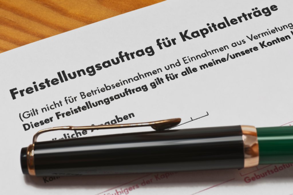 Auf dem Formular liegt ein Füller. Die Papierseite ist ein Freistellungsauftrag für Kapitalerträge und muss ausgefüllt werden.