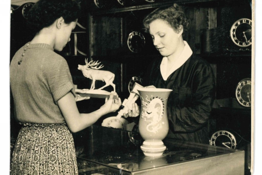 eine Frau gießt eine Tasse Wasser