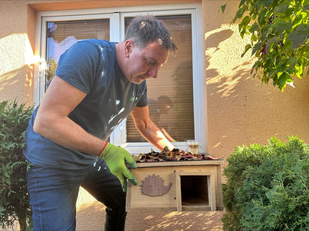 ein Mann in einem blauen Hemd und grünen Handschuhen